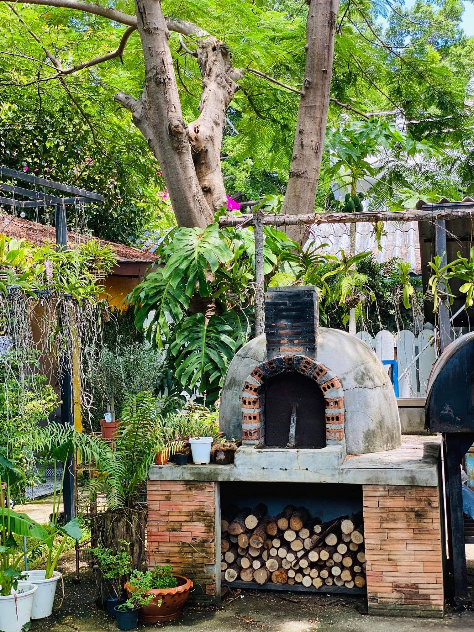 Wood-fired pizza oven surrounded by tropical garden at Laciana By The Sea, Italian restaurant Hua Hin